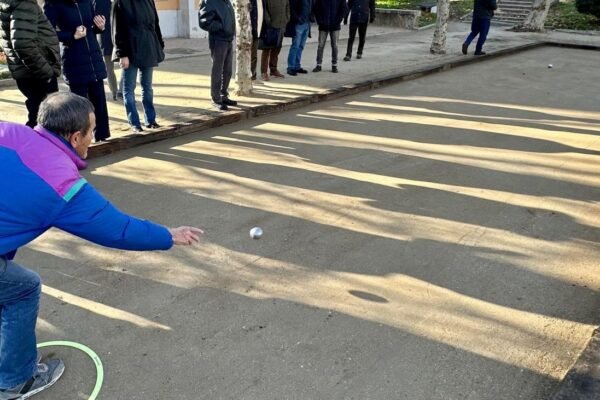 Un hombre lanza las bolas en un juego de petanca